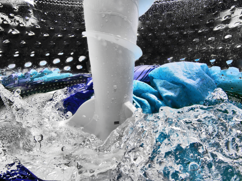 Clothing agitating inside of the washer with water Clothing agitating inside of the washer with water
