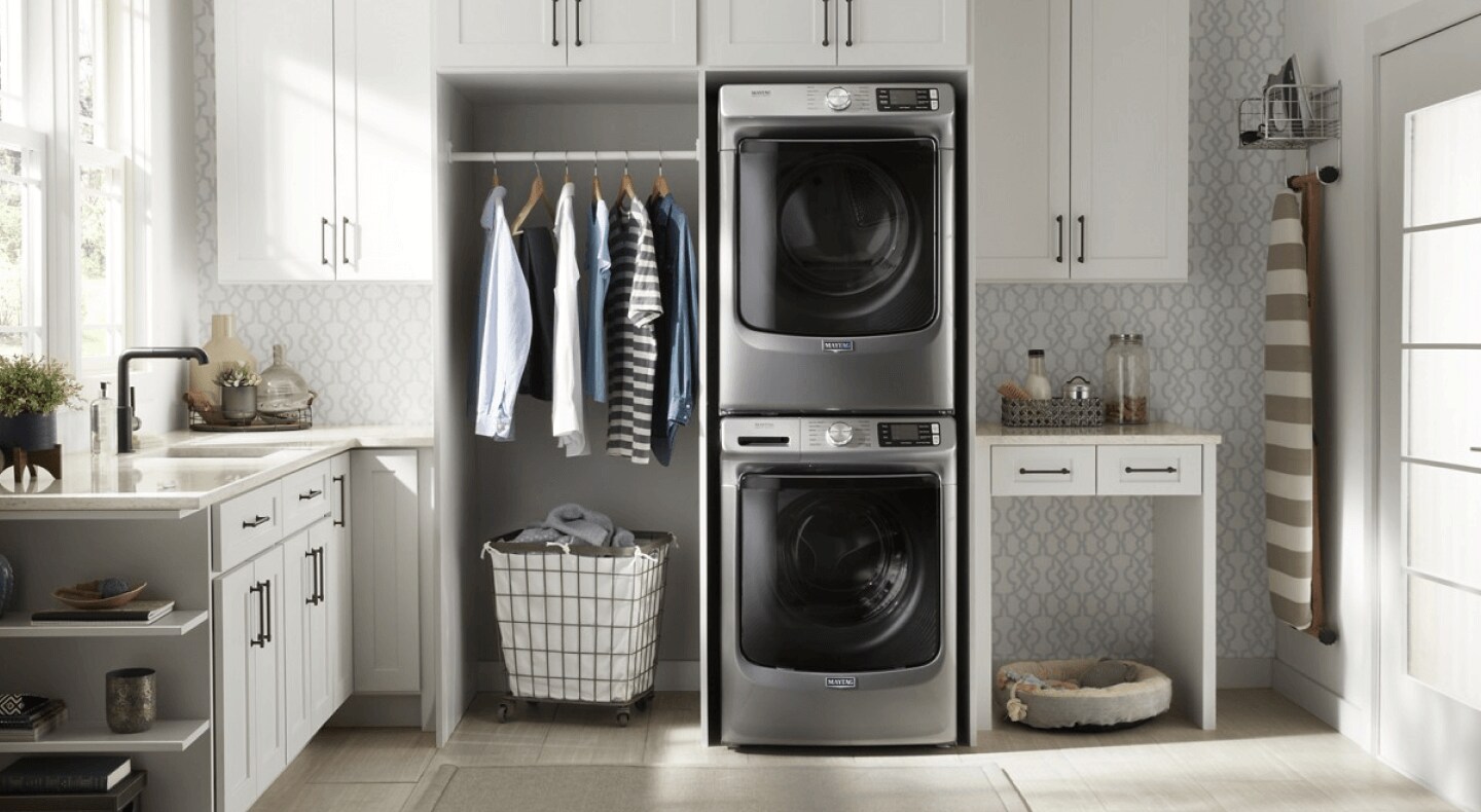 Front load washer and dryer set stacked in a laundry room