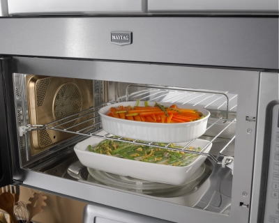 Inside of an open microwave with two dishes