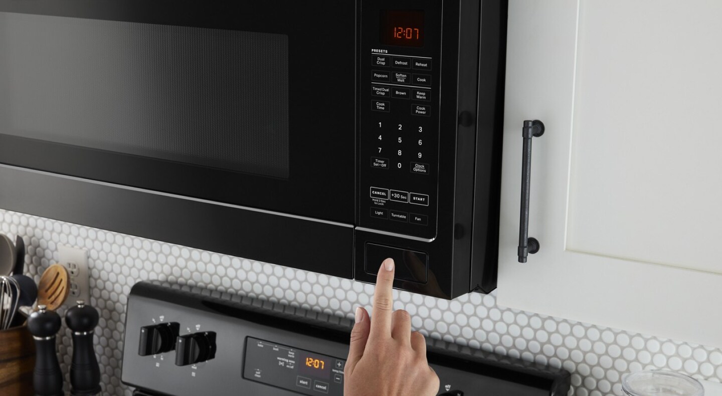 Hand making a selection on a microwave