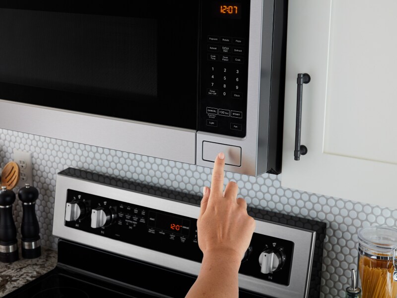 Person pressing open button on microwave Person pressing open button on microwave