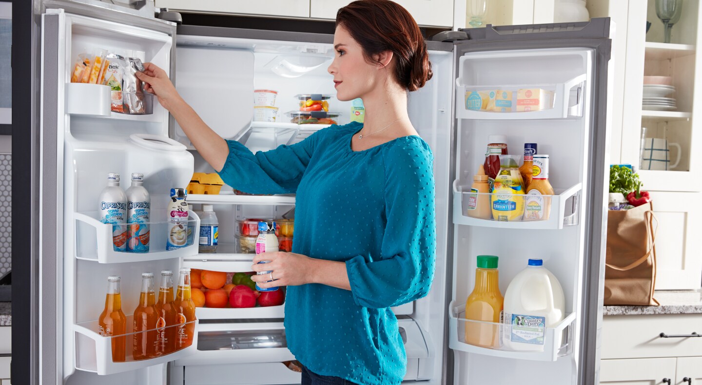 Person placing items in refrigerator Person placing items in refrigerator