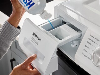 Person adding detergent to a washing machine