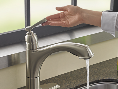 A person turning on a sink faucet