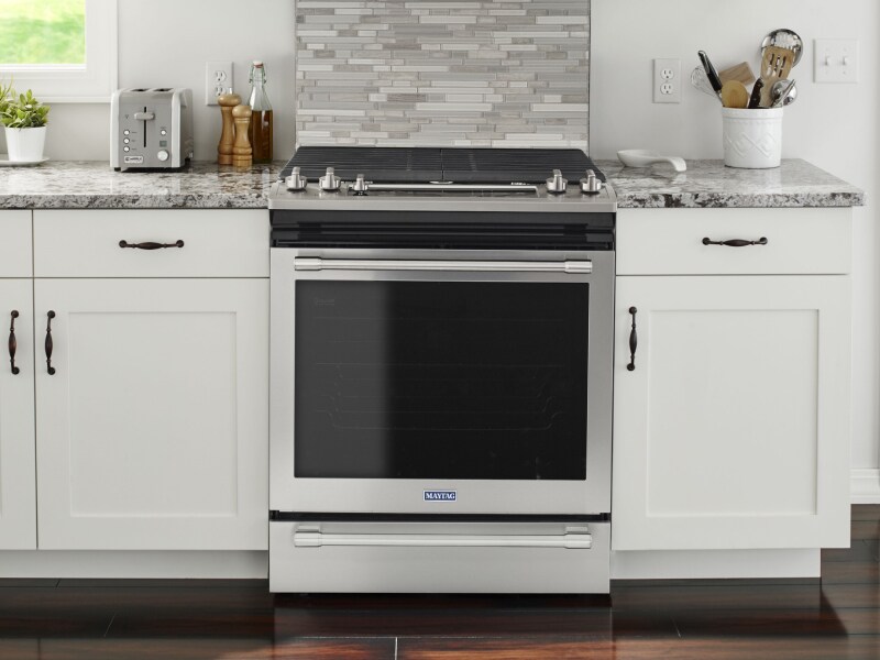 A stainless steel oven surrounded by white cabinetry A stainless steel oven surrounded by white cabinetry