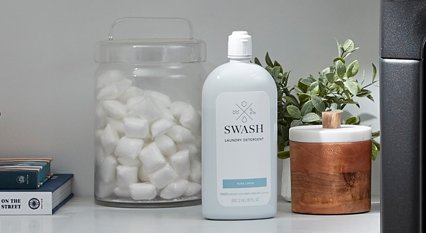Swash® detergent next to a glass jar of laundry pods Swash® detergent next to a glass jar of laundry pods