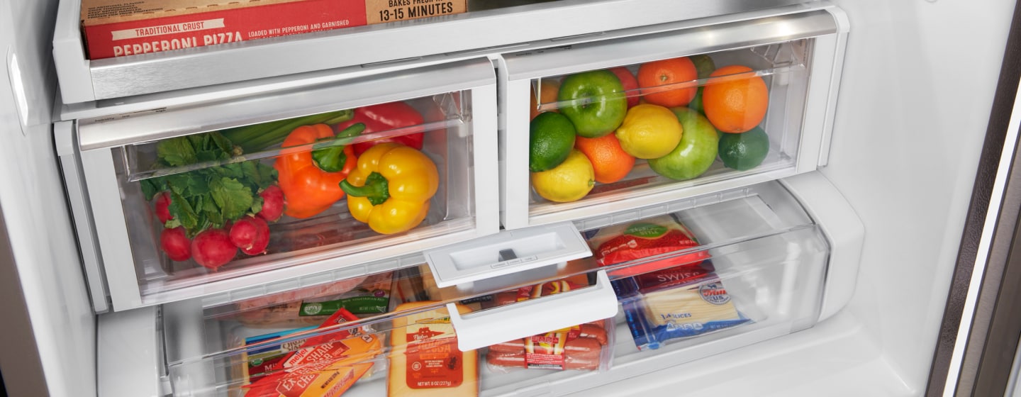 Left crisper drawer filled with colorful peppers and right crisper drawer filled with fresh fruit Left crisper drawer filled with colorful peppers and right crisper drawer filled with fresh fruit