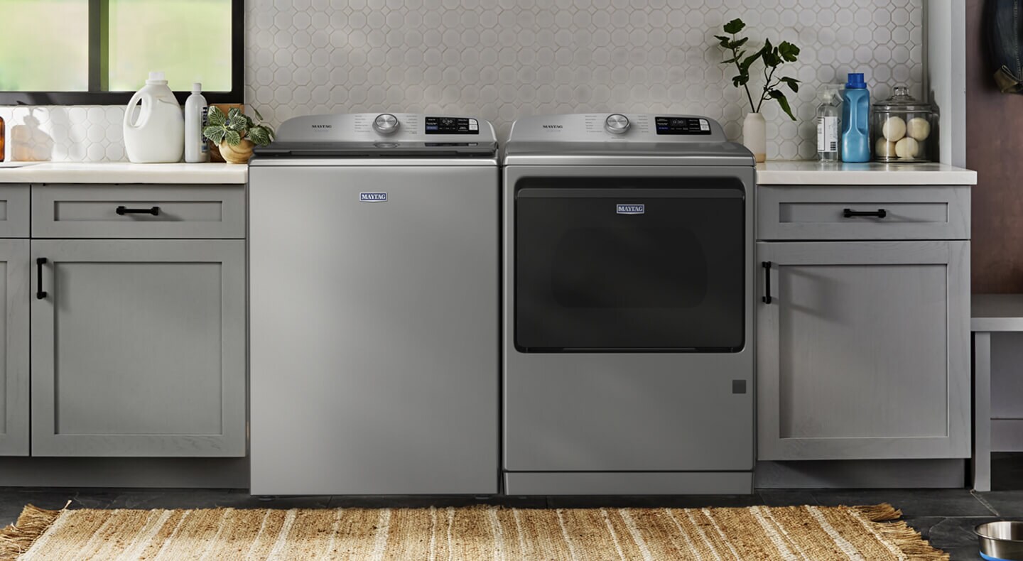 Maytag® top loading washer and dryer in a laundry room