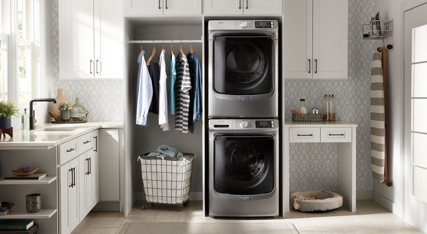 A neat laundry room in a home with a stackable washer and dryer