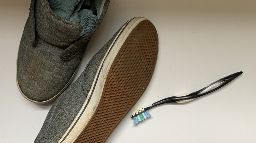 Shoes stuffed with rags next to a toothbrush