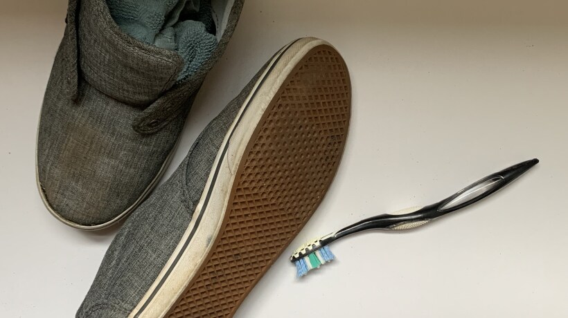 Shoes stuffed with rags next to a toothbrush 