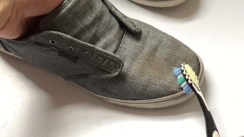 Shoes being cleaned with a toothbrush