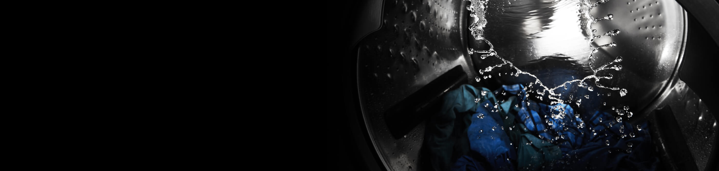 Blue and green clothing tumbling in a washer full of water