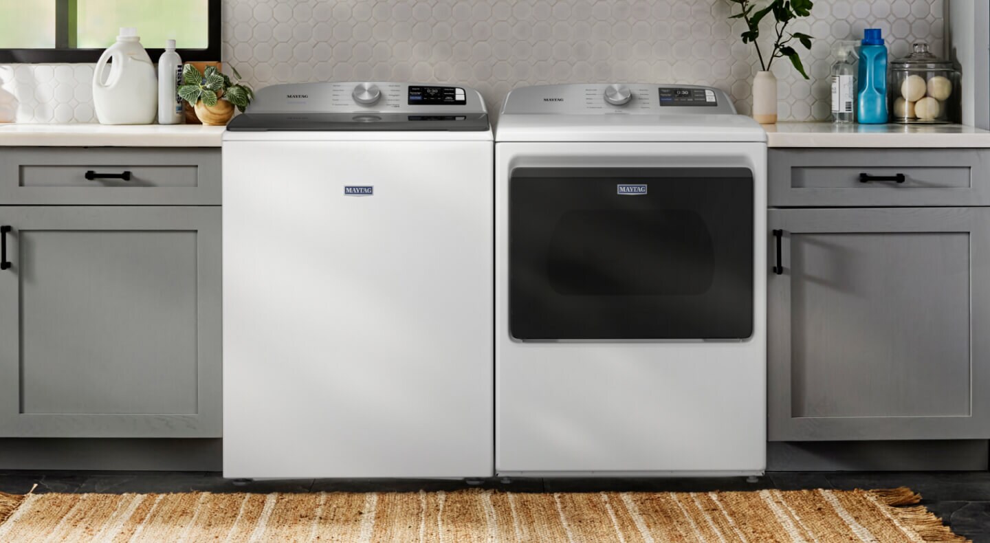 A white Maytag® top load laundry pair in a laundry room with gray cabinetry