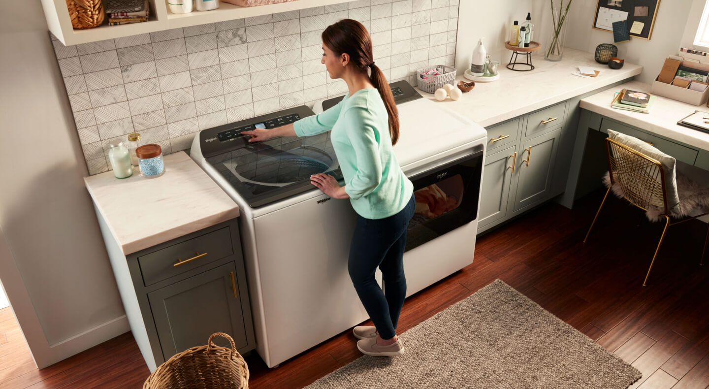 Overhead view of woman at washing machine Overhead view of woman at washing machine