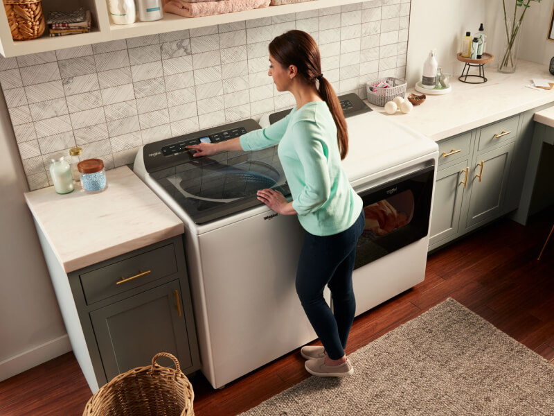 Overhead view of woman at washing machine Overhead view of woman at washing machine