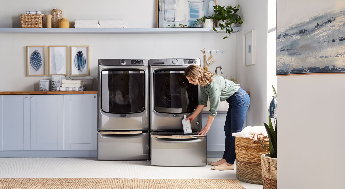 Woman removing product from dryer storage Woman removing product from dryer storage