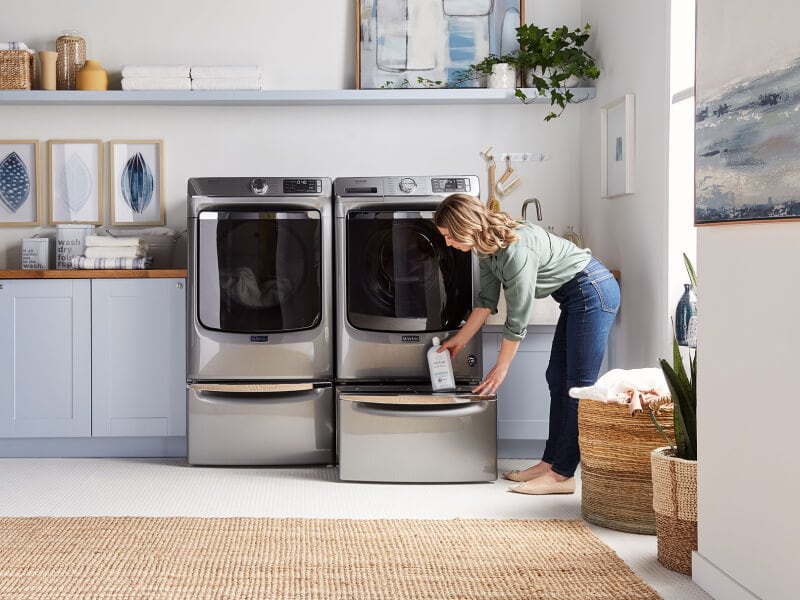 Woman removing product from dryer storage Woman removing product from dryer storage