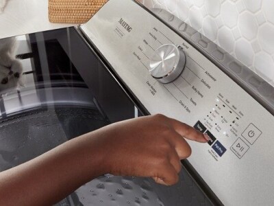 Person selecting cycle settings on washing machine