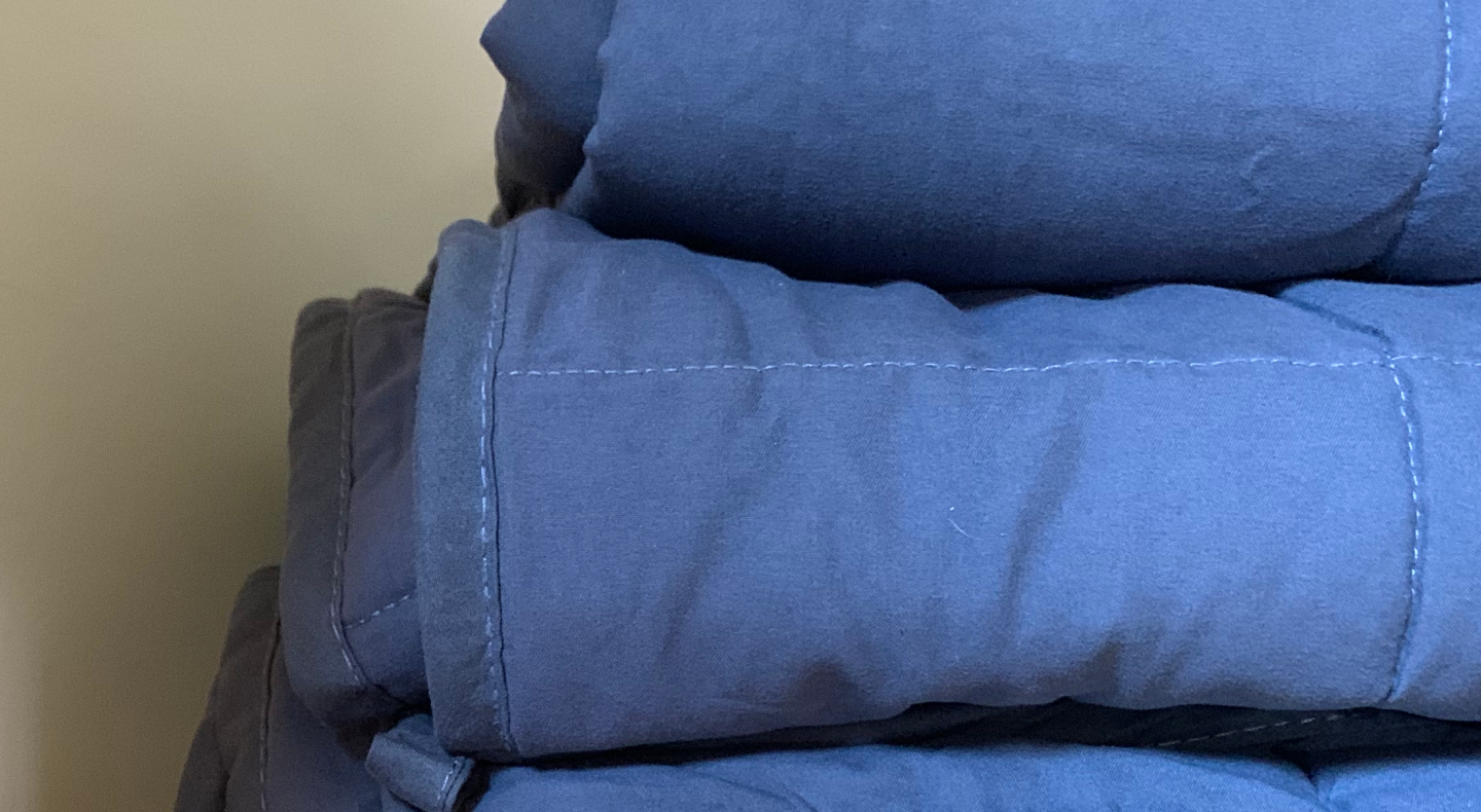Stack of folded blue comforters Stack of folded blue comforters