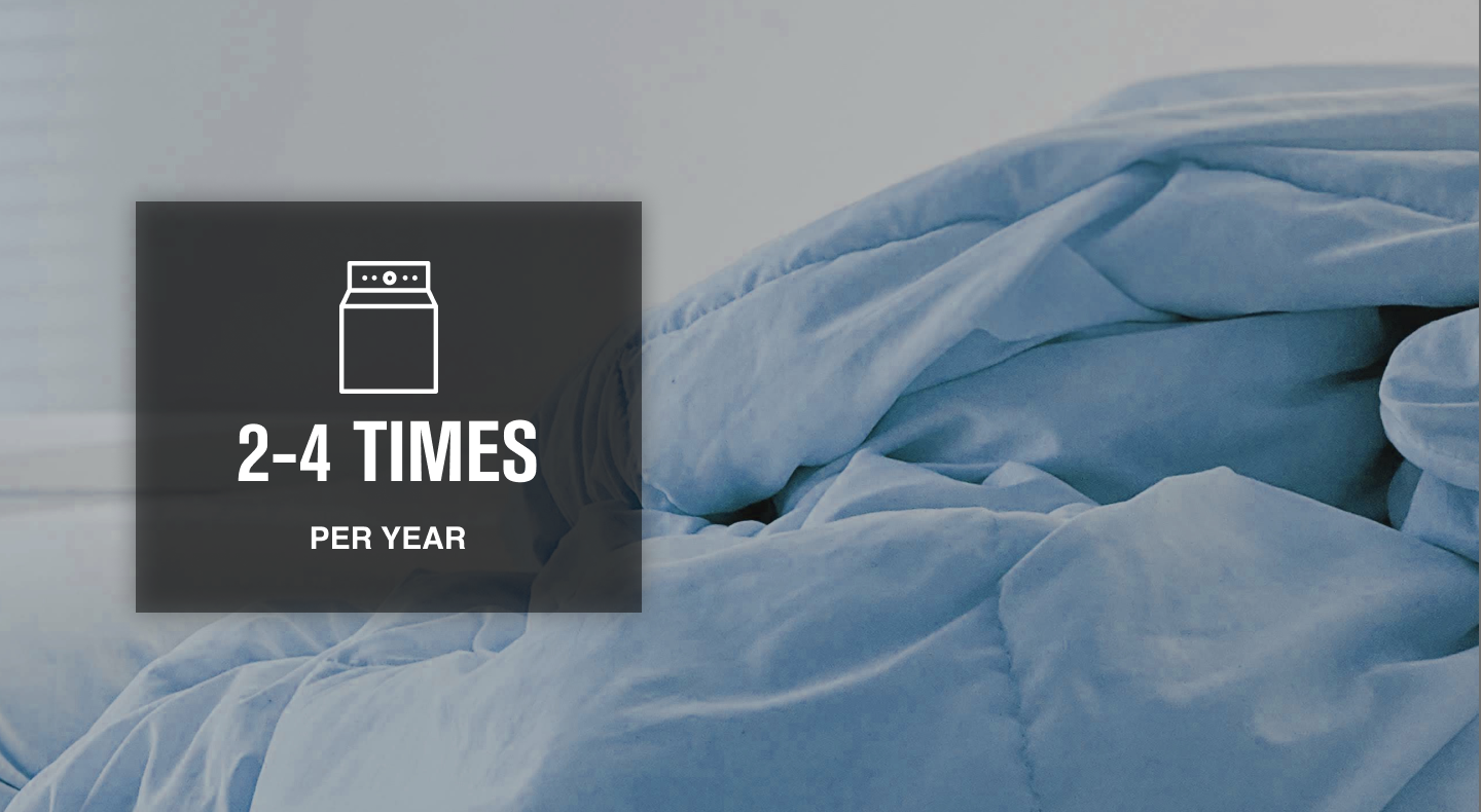 Fluffy blue comforter with washer icon overlaid  Fluffy blue comforter with washer icon overlaid