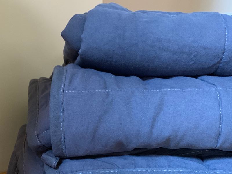 Stack of folded blue comforters Stack of folded blue comforters