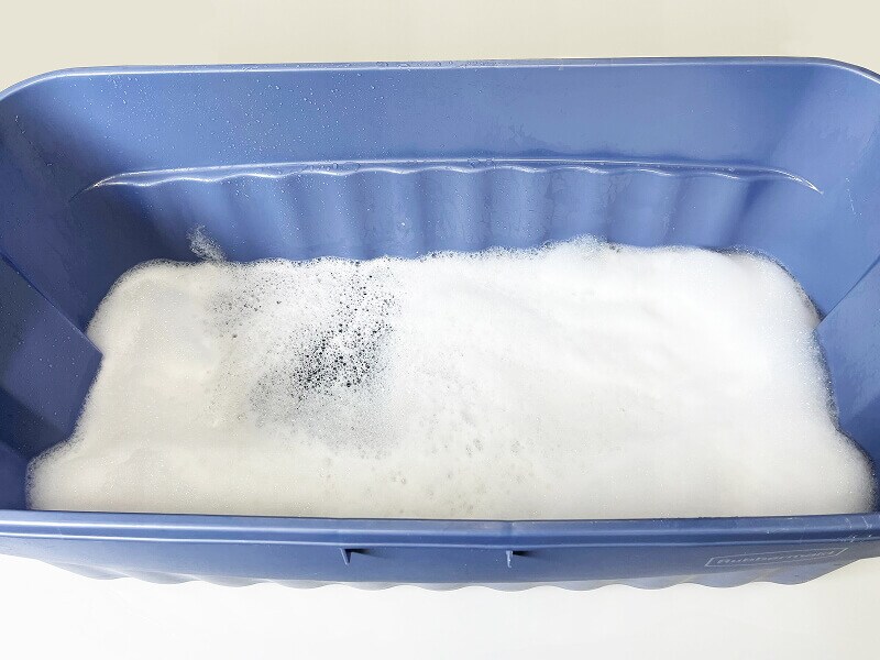 A basin filled with water and pet-safe detergent