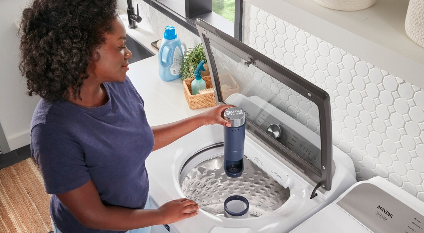 Person removing Maytag® Pet Pro Filter Person removing Maytag® Pet Pro Filter