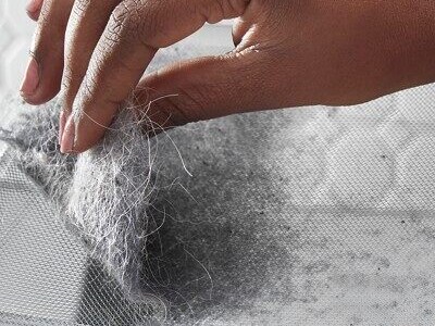 Hand removing a clump of pet hair