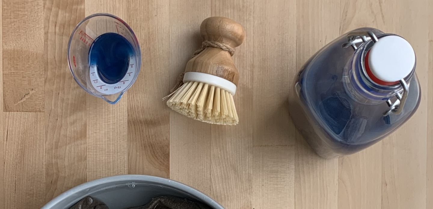 Bristle brush and measuring cup filled with liquid detergent Bristle brush and measuring cup filled with liquid detergent