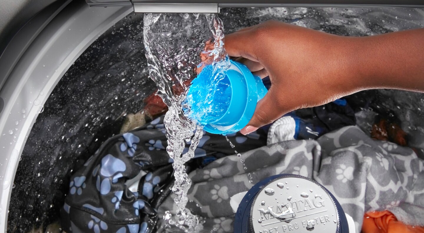 Person rinsing detergent cap Person rinsing detergent cap