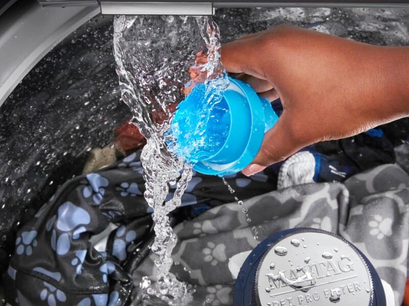 Person rinsing detergent cap Person rinsing detergent cap