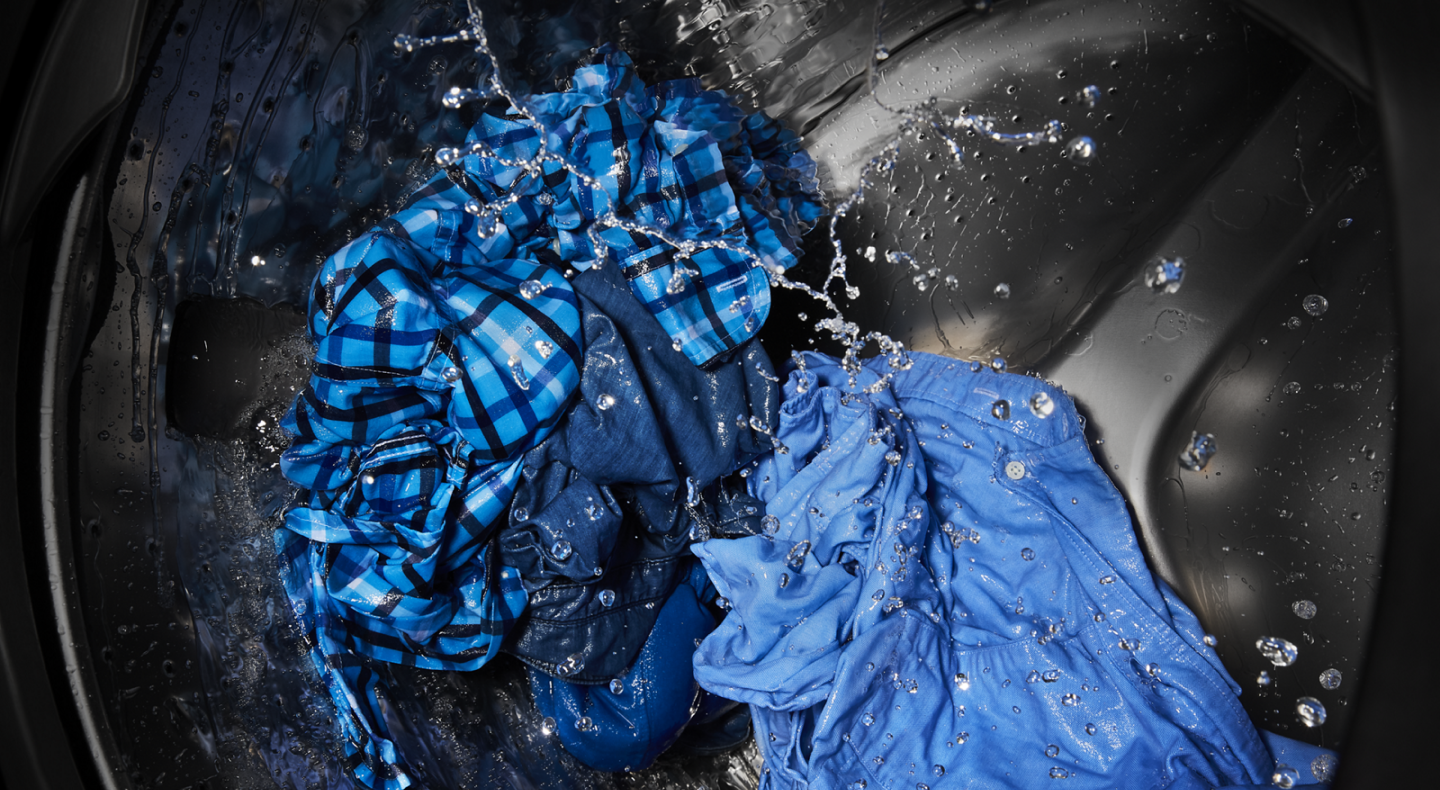 The interior of a Maytag® washer tub washing clothing items. The interior of a Maytag® washer tub washing clothing items.