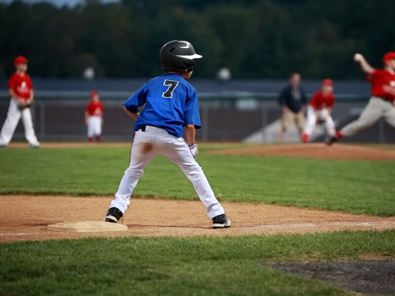 The back of a child in a baseball uniform