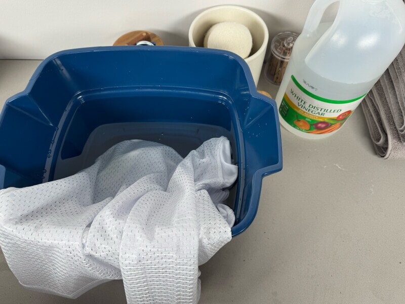 A jersey soaking in a bucket of water and vinegar
