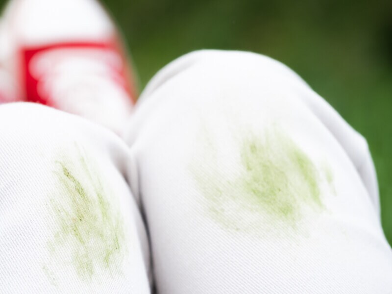 A close-up of grass stains on the knees of a sports uniform