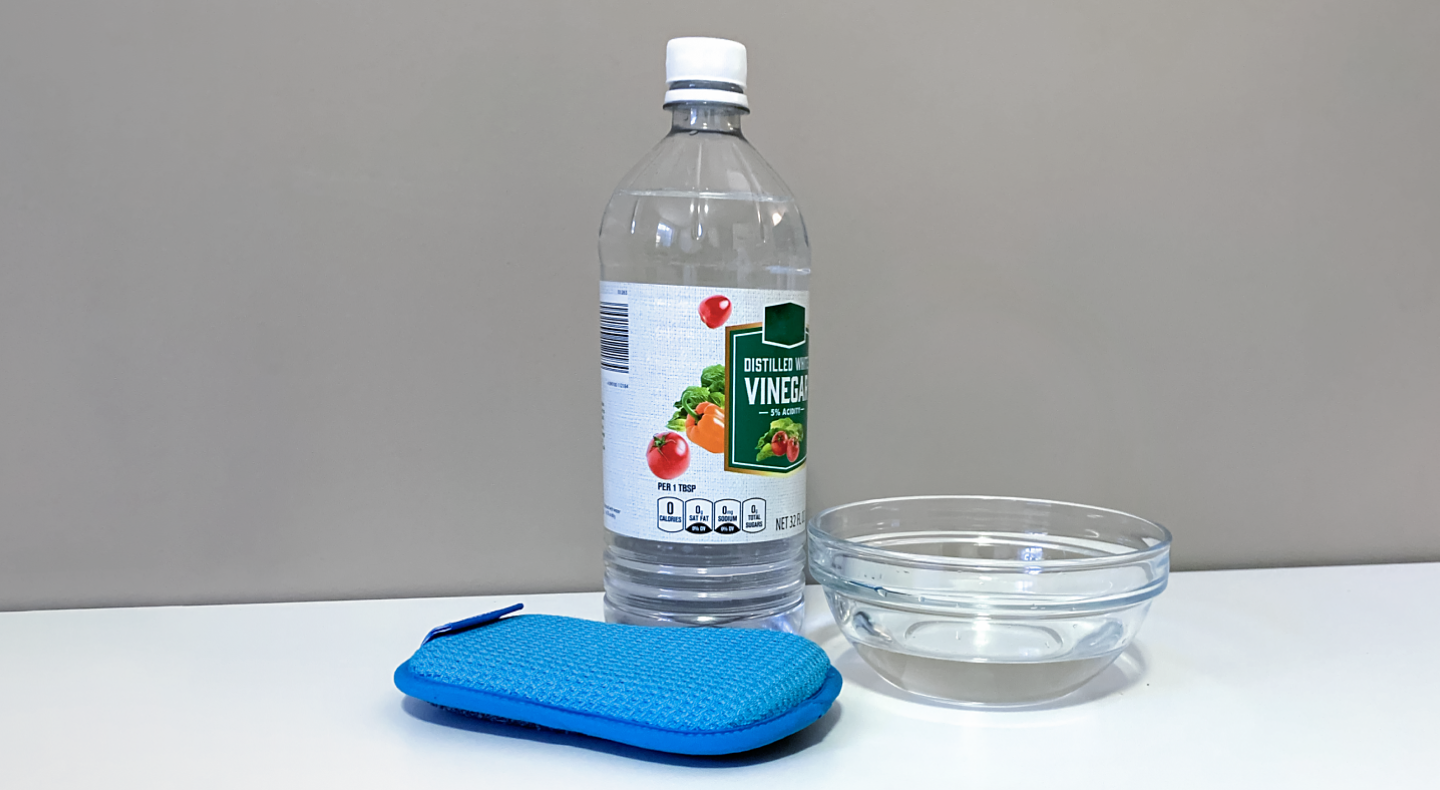 White vinegar, a sponge and a bowl White vinegar, a sponge and a bowl