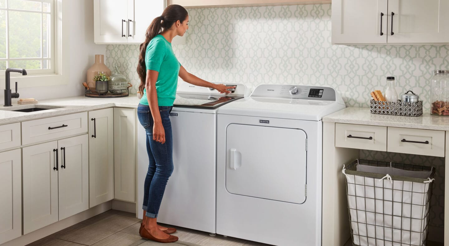 Person selecting a setting on a washing machine Person selecting a setting on a washing machine