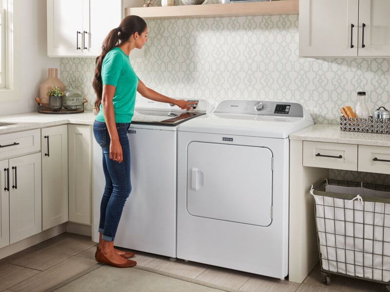 Person selecting a setting on a washing machine Person selecting a setting on a washing machine