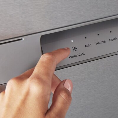 Person selecting the PowerBlast® cycle on a Maytag brand dishwasher