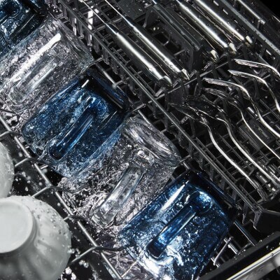 Close-up of cups washing in the upper rack of a dishwasher
