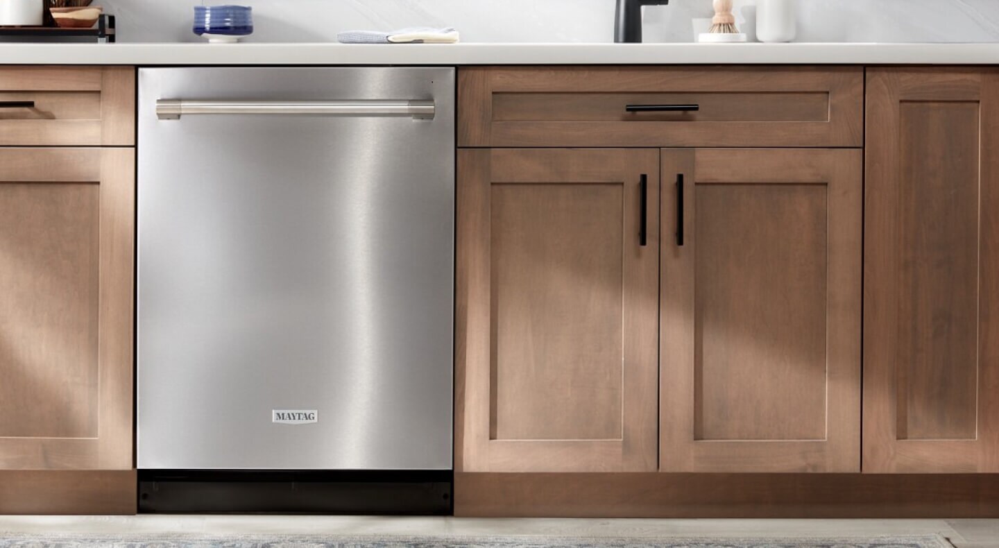 Stainless steel Maytag® dishwasher in brown, farmhouse-style kitchen cabinets