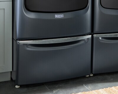 A laundry pedestal under a Maytag® washing machine
