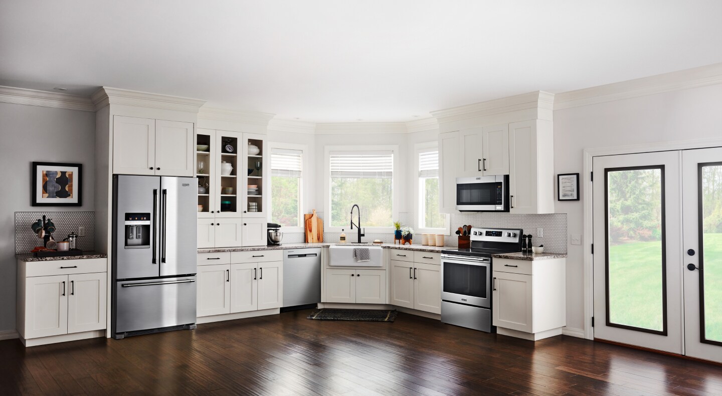 Open kitchen with white cabinetry and stainless steel French door refrigerator Open kitchen with white cabinetry and stainless steel French door refrigerator