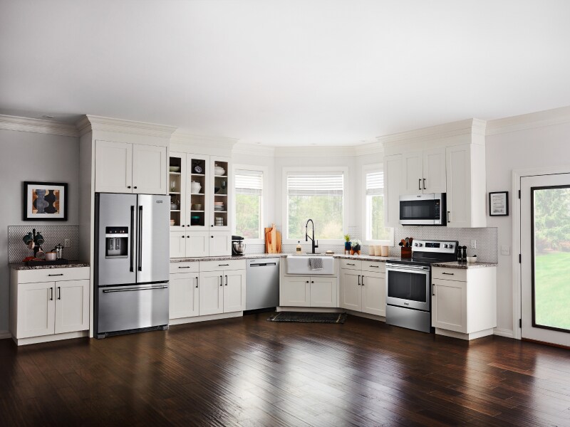 Open kitchen with white cabinetry and stainless steel French door refrigerator Open kitchen with white cabinetry and stainless steel French door refrigerator