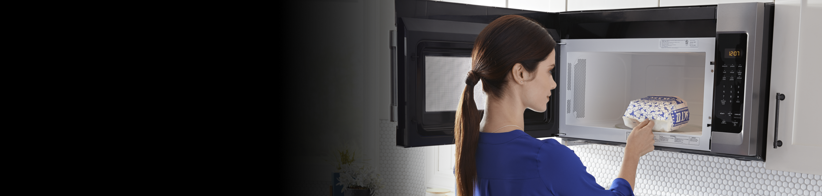 Person removing popcorn from the microwave