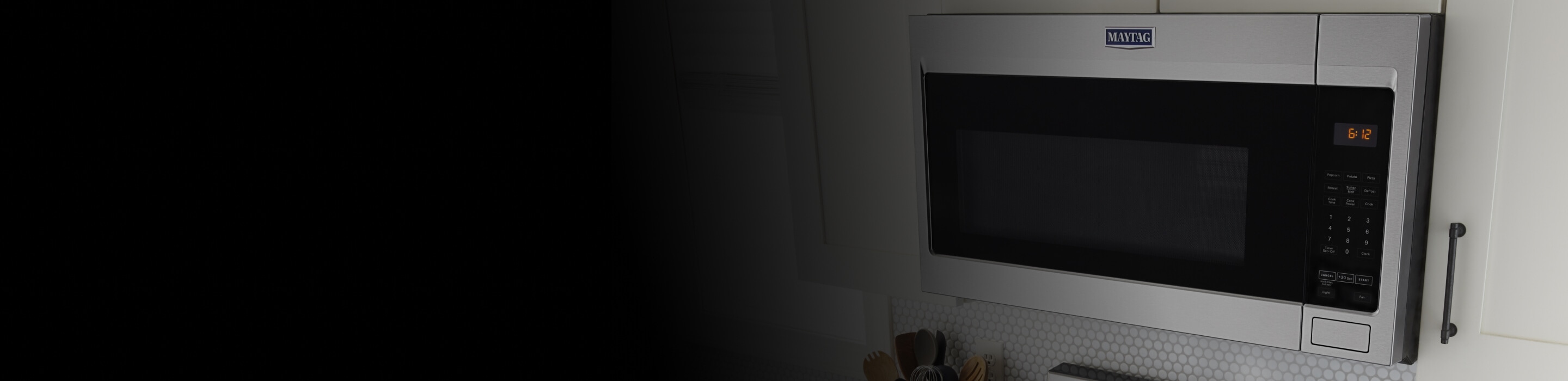 Over-the-range microwave in white cabinets.