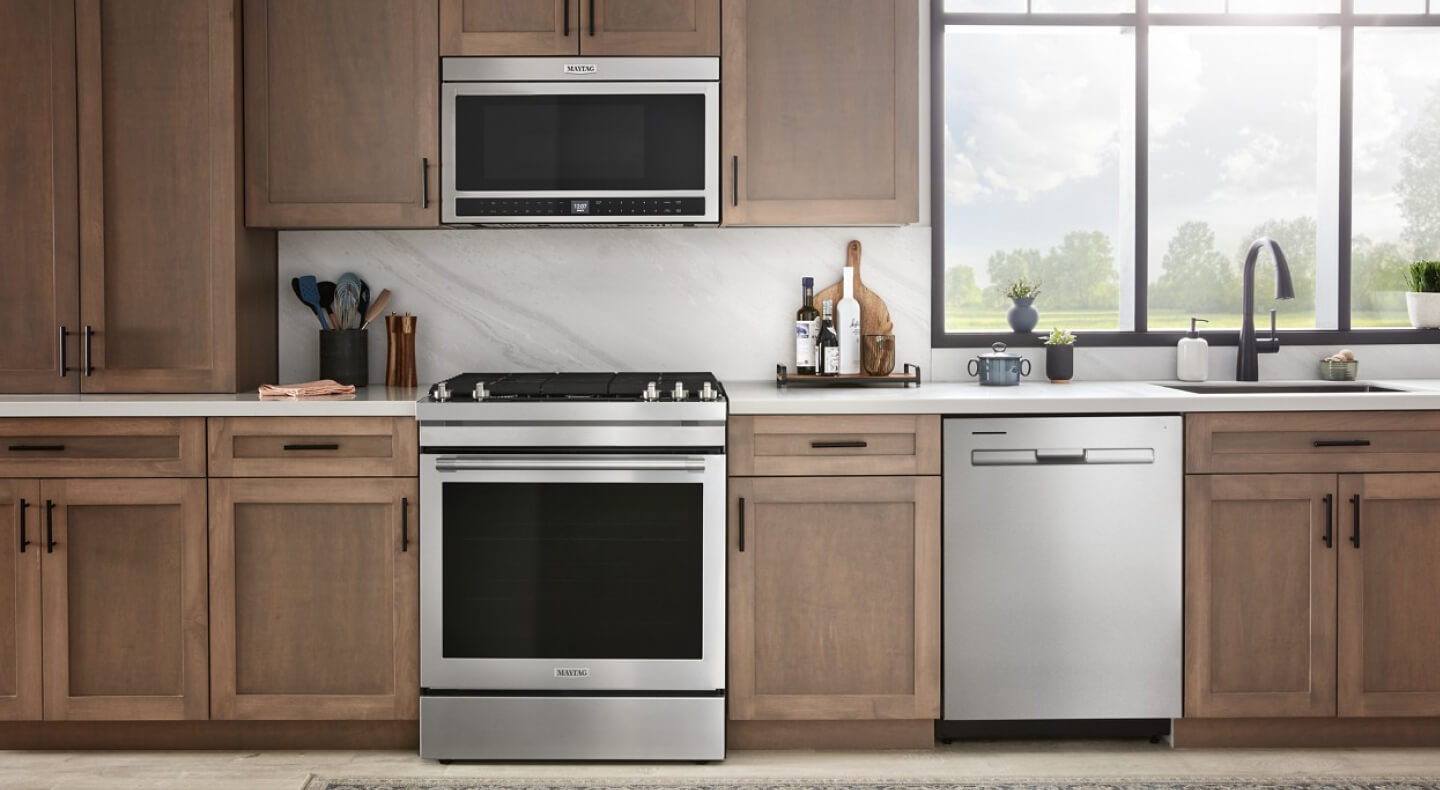 Maytag® over-the-range microwave and gas range in a rustic kitchen