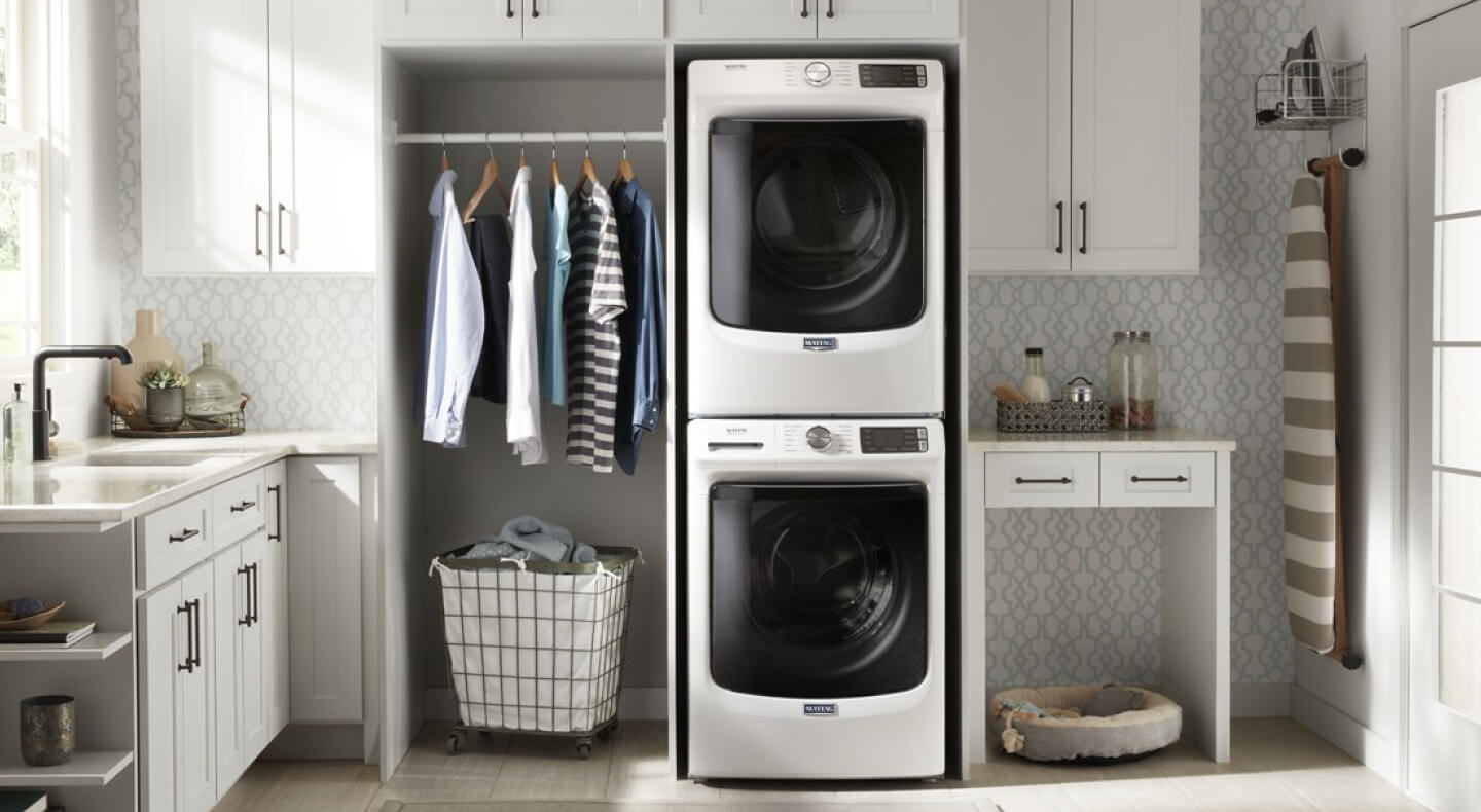 Laundry room with stacked washer and dryer by Maytag brand