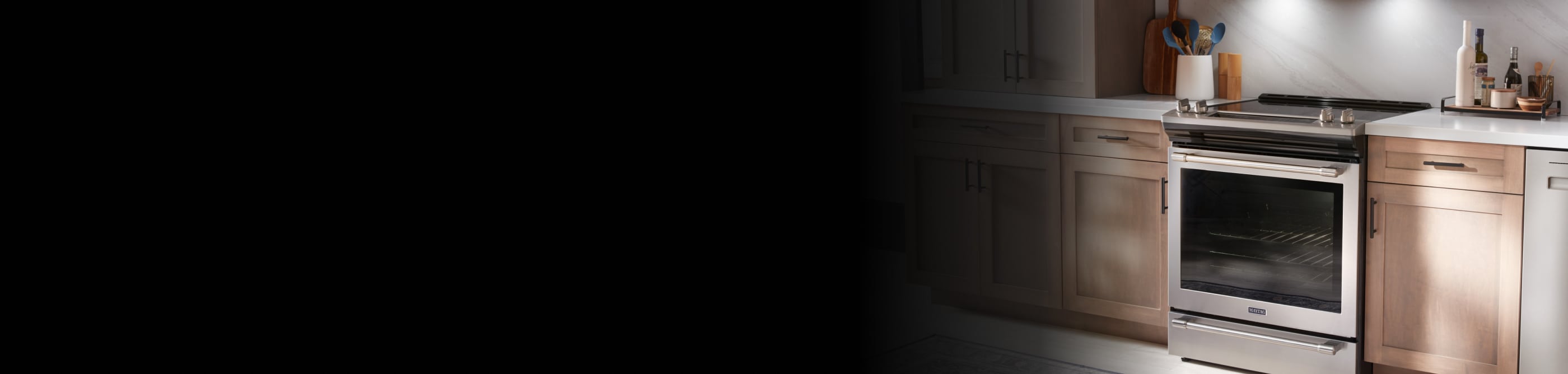 Stainless steel Maytag® electric range in brown cabinetry